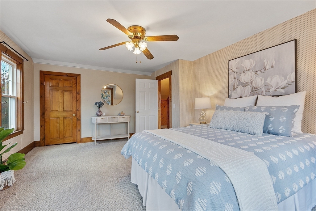 7 Groton-Harvard Road Ayer, MA 01432 - Photo 18 of 35 a spacious bedroom with a bed and a chandelier