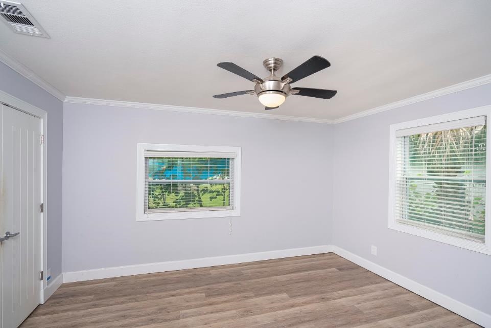 144 Menendez Road St. Augustine, FL 32080 - Photo 15 of 16 Unfurnished room featuring light wood-style floors, ornamental molding, and a ceiling fan