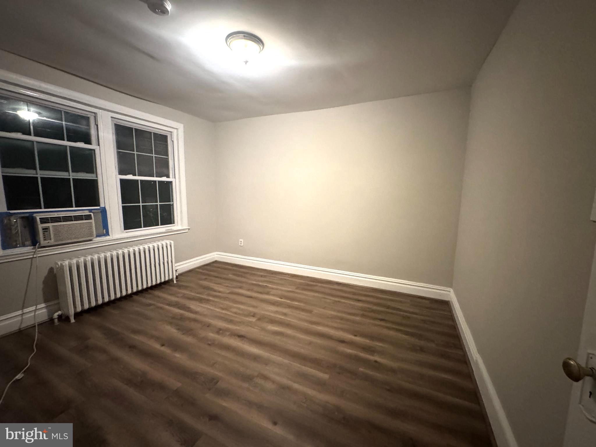 228 Ascot Place Northeast Washington, DC 20002 - Photo 12 of 14 an empty room with wooden floor and windows