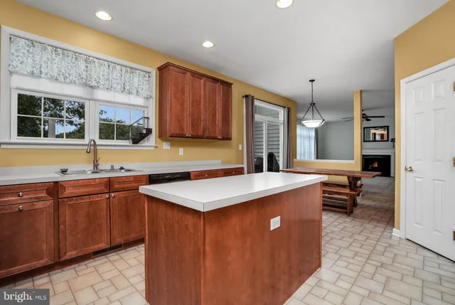 a kitchen with stainless steel appliances granite countertop a stove top oven a refrigerator and a sink with wooden cabinets