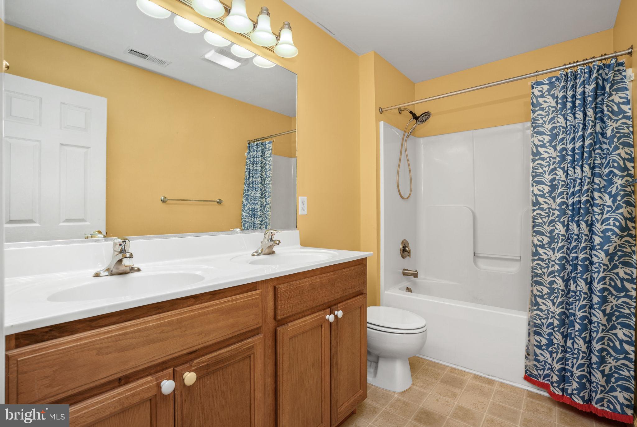2745 Stockton Road Pocomoke City, MD 21851 - Photo 33 of 57 a bathroom with a granite countertop sink toilet a large mirror a shower and a bathtub
