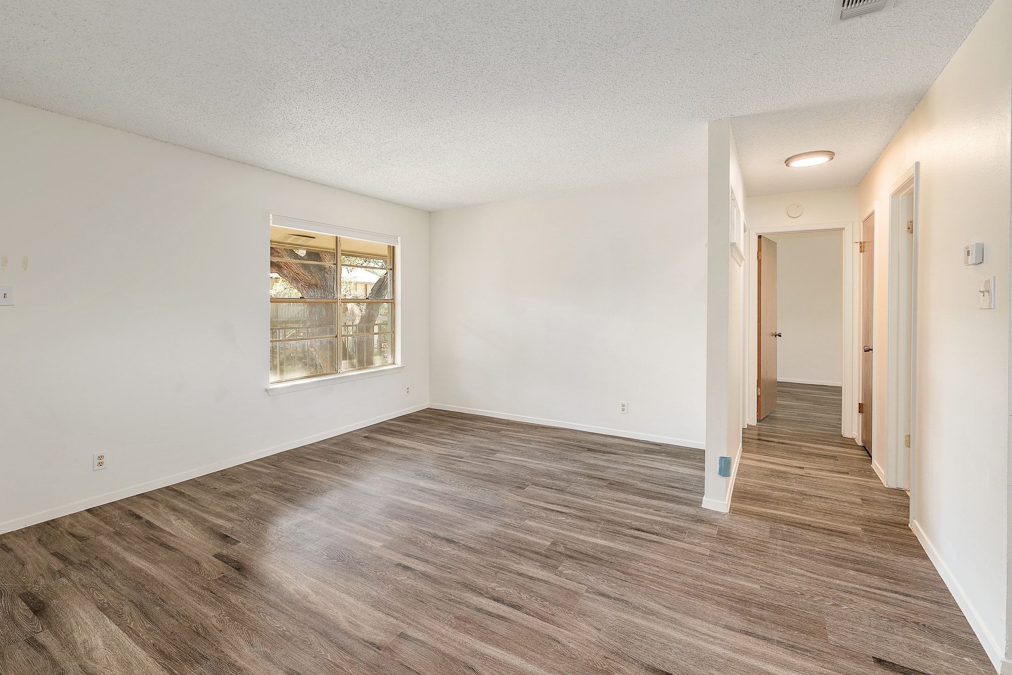 509 Cedar Drive, Unit 206 Georgetown, TX 78628 - Photo 3 of 12 an empty room with wooden floor and windows