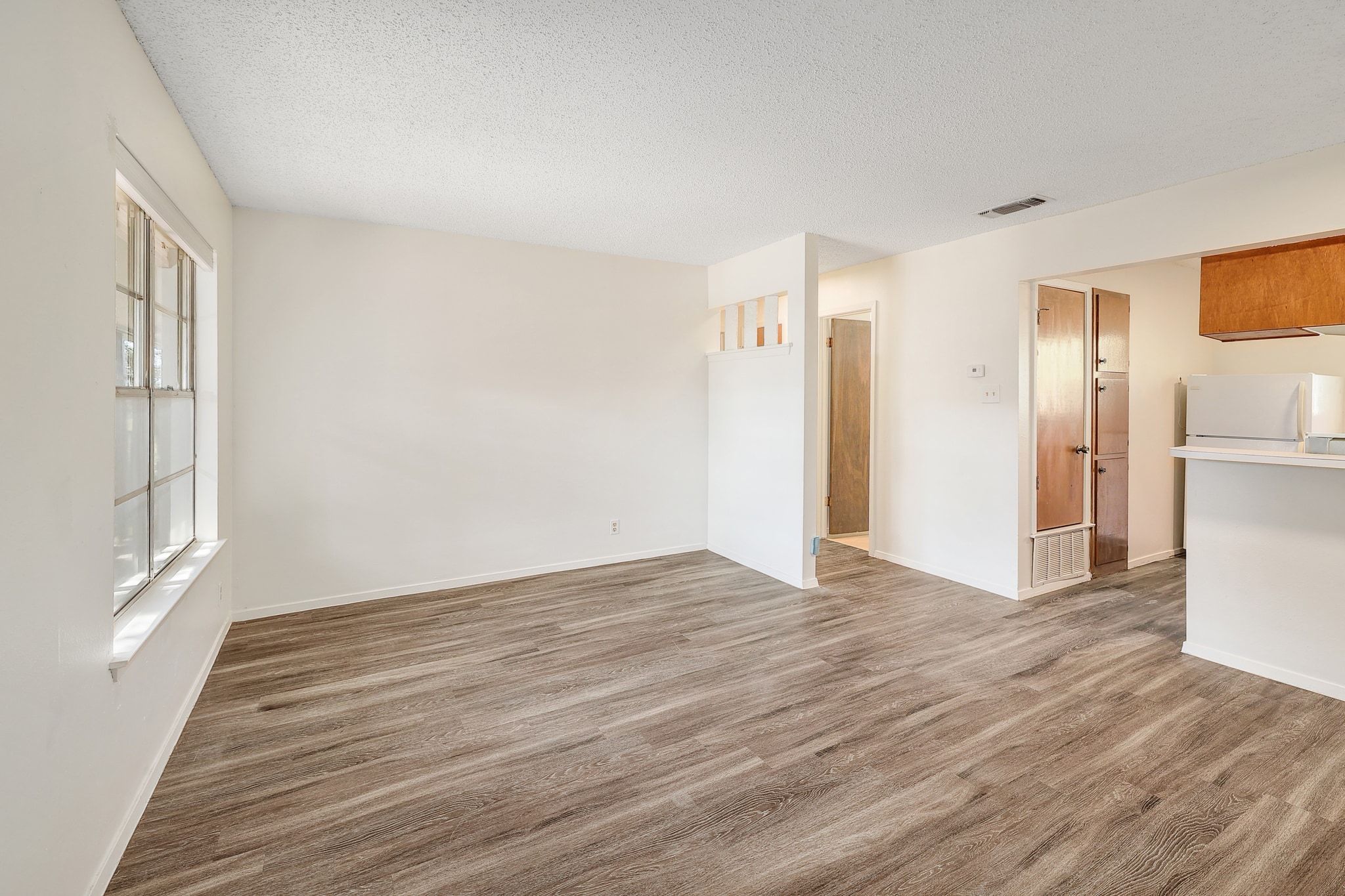 509 Cedar Drive, Unit 206 Georgetown, TX 78628 - Photo 4 of 12 a view of an empty room with wooden floor and a window