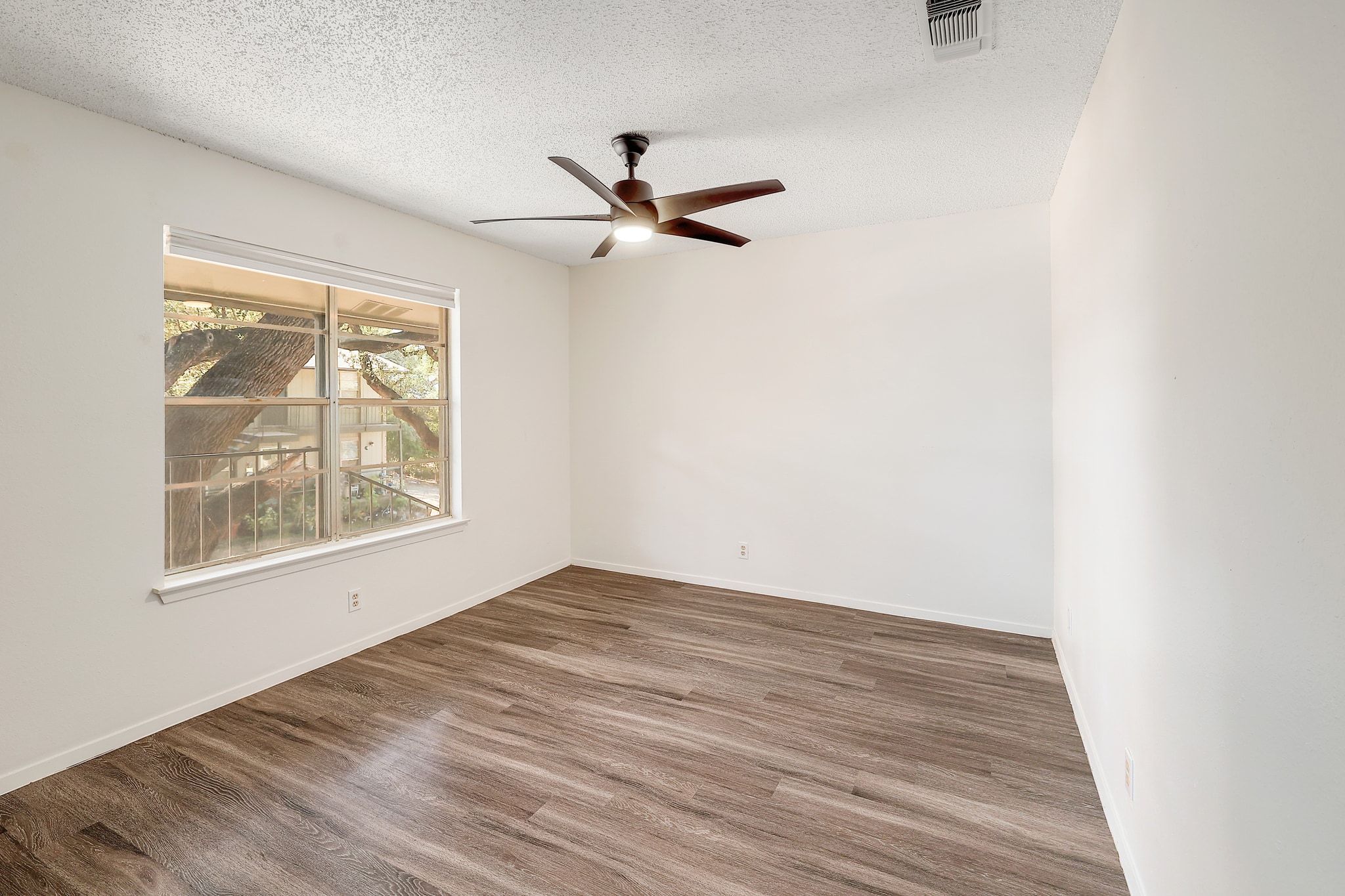 509 Cedar Drive, Unit 206 Georgetown, TX 78628 - Photo 10 of 12 an empty room with wooden floor ceiling fan and windows