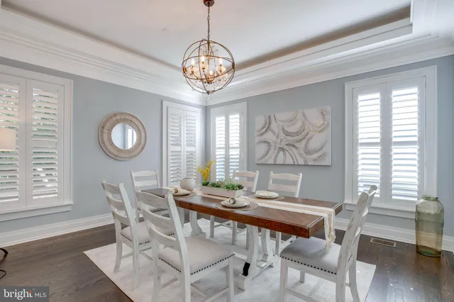 a kitchen with stainless steel appliances granite countertop a stove a sink and a dining table with wooden floor