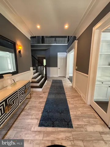 a view of a hallway with wooden floor and entryway