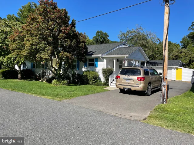 a white house covered with tall trees