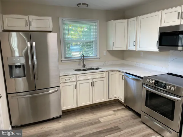 a kitchen with appliances a sink and a window