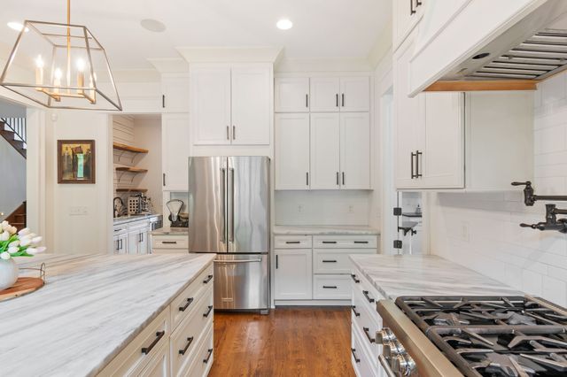 a kitchen with granite countertop a sink a stove and cabinets