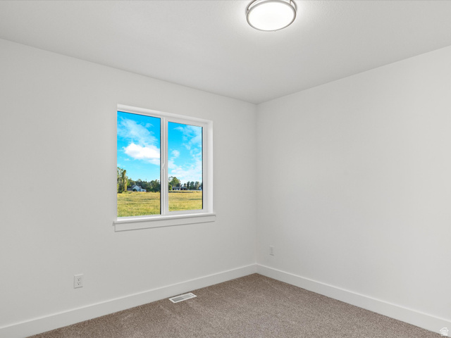 1267 West 2350 South Perry, UT 84302 - Photo 35 of 35 Carpeted room featuring a single window, white trim, and a ceiling-mounted light fixture