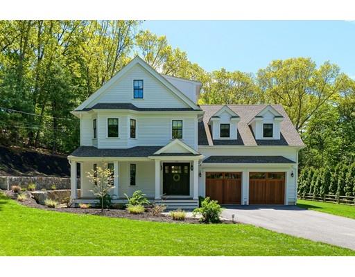a front view of a house with a yard and potted plants