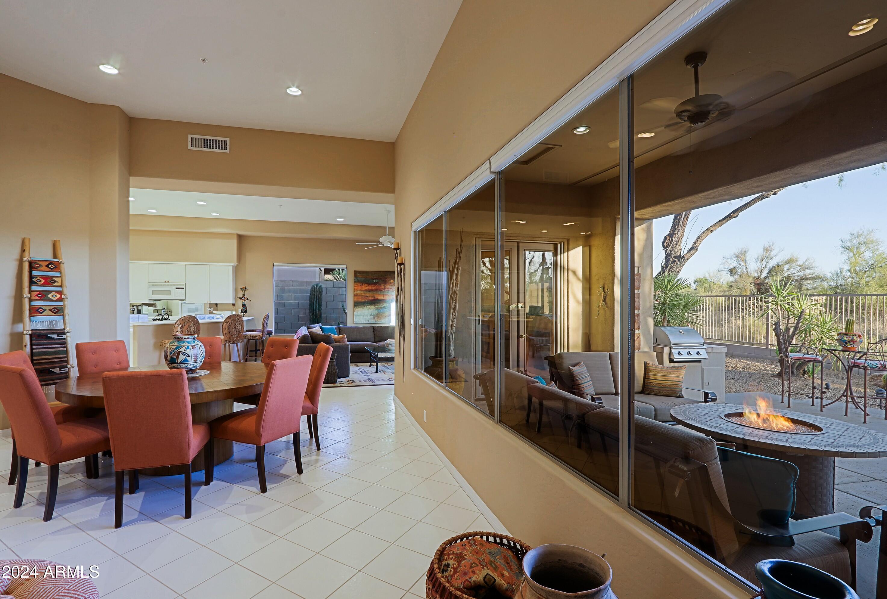 6135 East Evening Glow Drive Scottsdale, AZ 85266 - Photo 12 of 118 a dining room with furniture and a floor to ceiling window