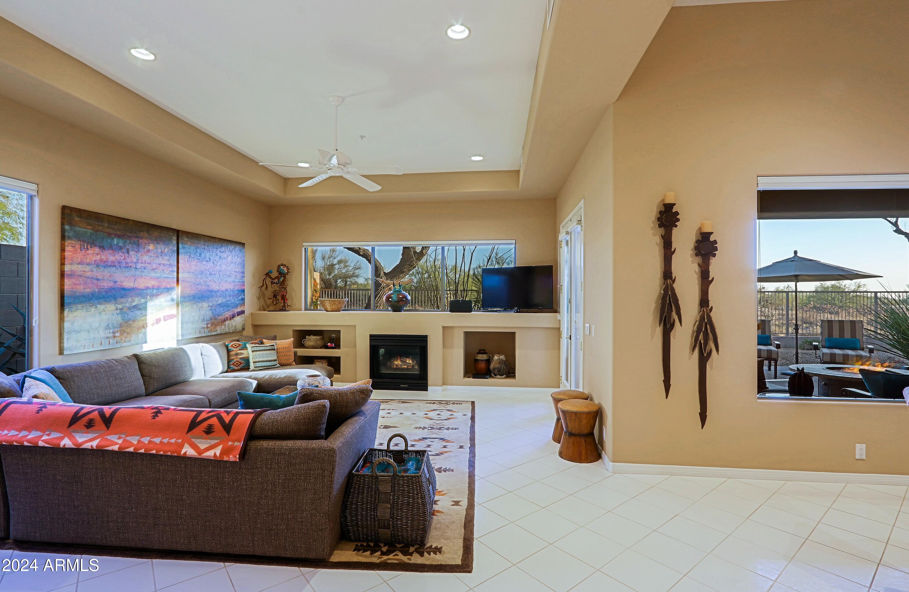6135 East Evening Glow Drive Scottsdale, AZ 85266 - Photo 18 of 118 a living room with furniture a flat screen tv and a floor to ceiling window