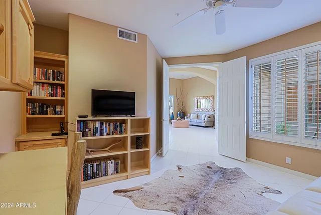 a bedroom with bed and paintings on the wall