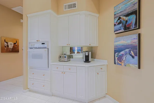 a view of a patio with a table and chairs under an umbrella with potted plants
