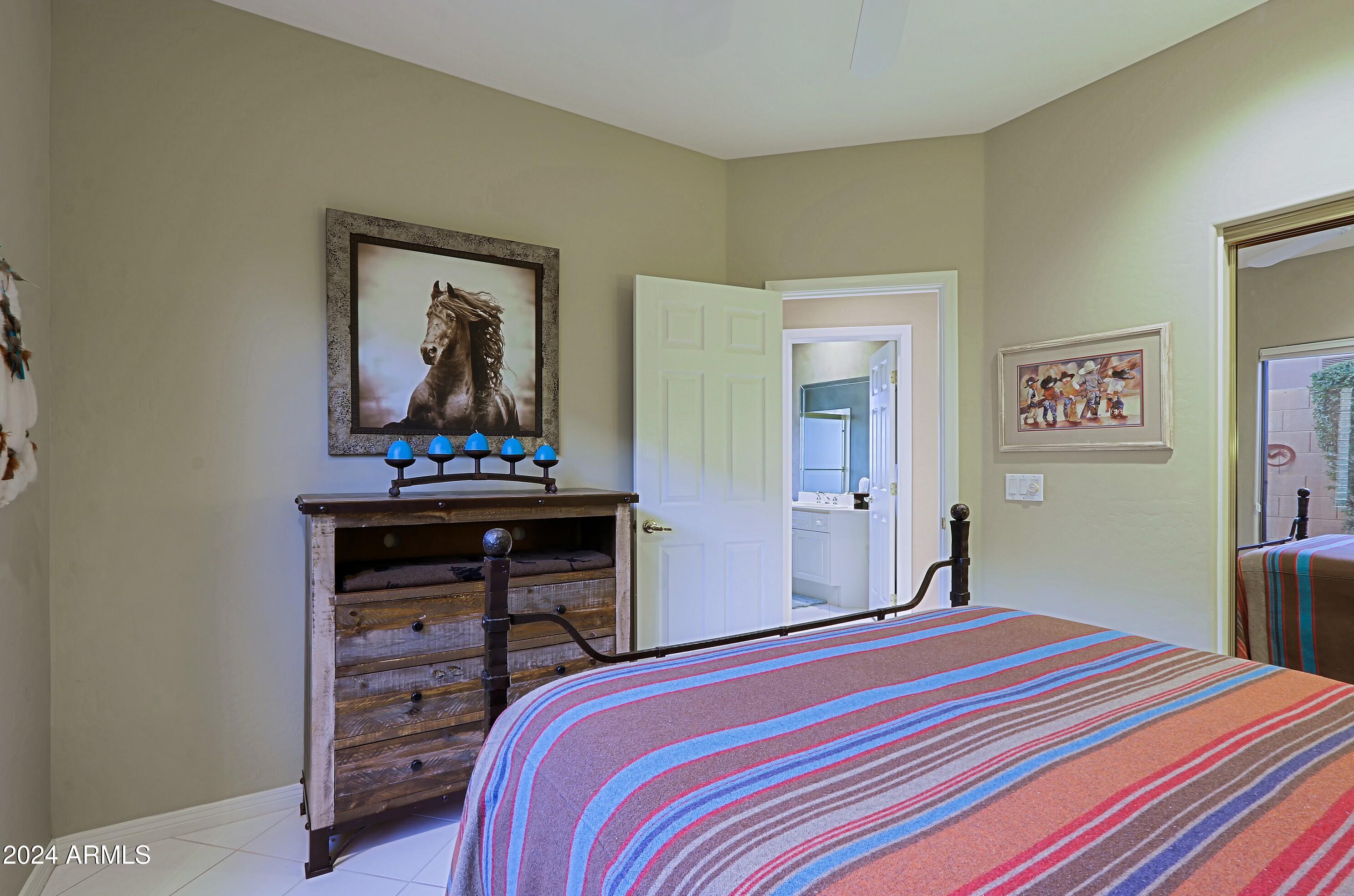 6135 East Evening Glow Drive Scottsdale, AZ 85266 - Photo 45 of 118 a bedroom with bed and paintings on the wall