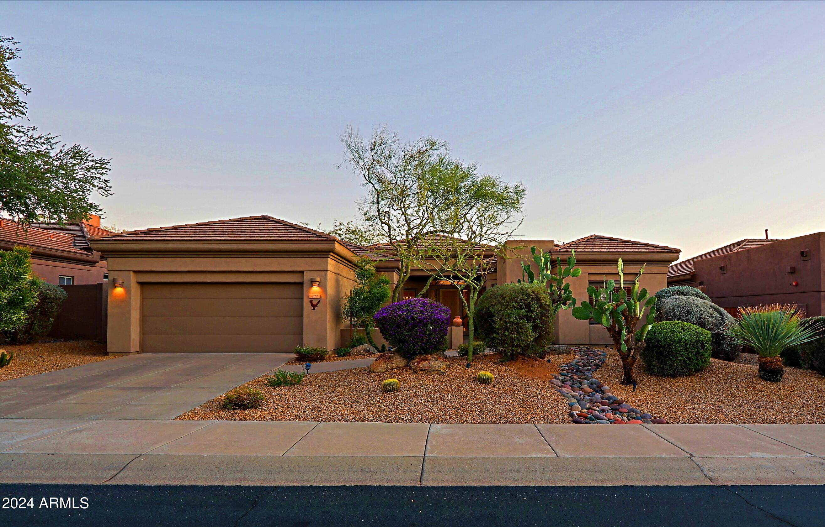 6135 East Evening Glow Drive Scottsdale, AZ 85266 - Photo 55 of 118 a front view of a house with a yard and garage
