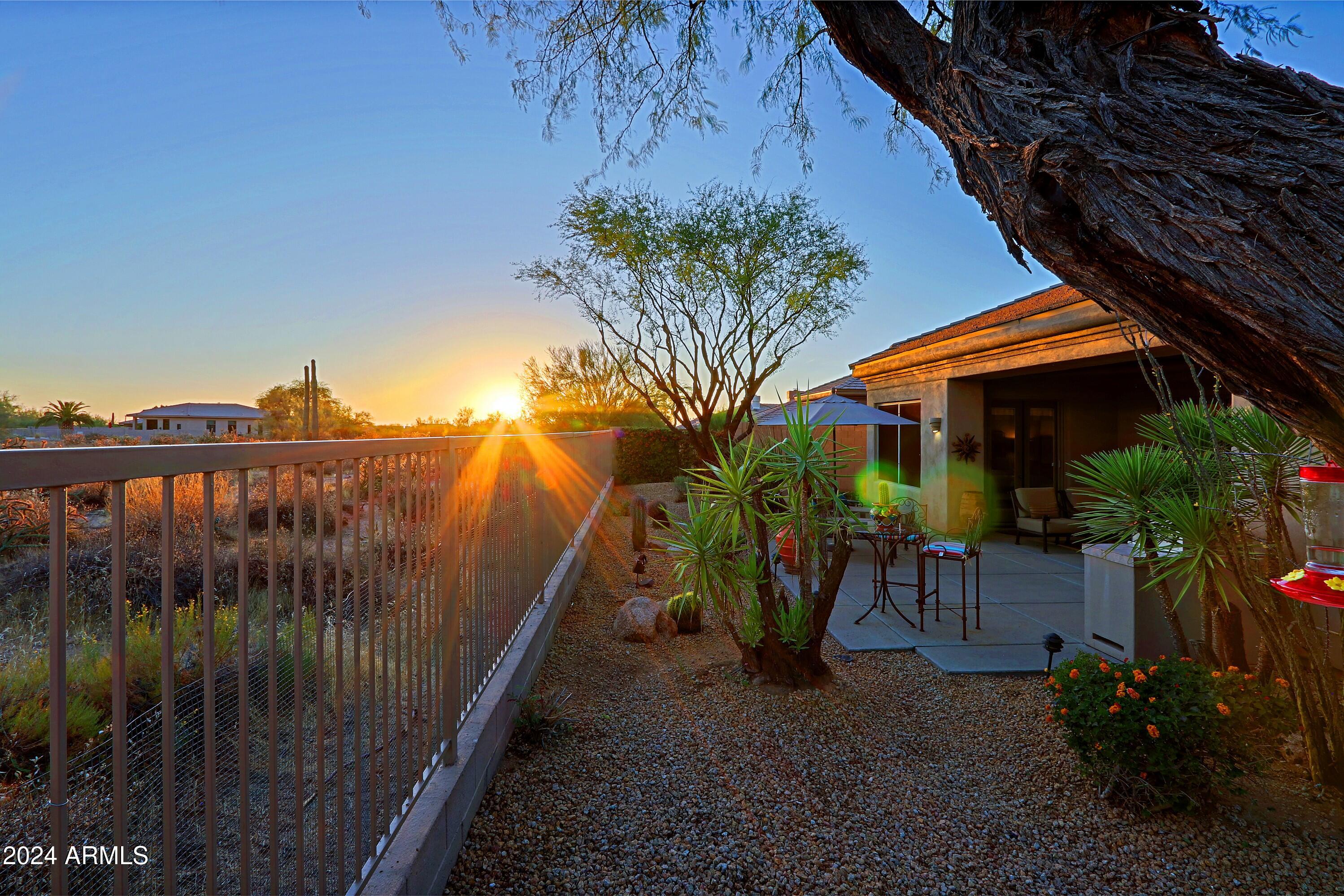 6135 East Evening Glow Drive Scottsdale, AZ 85266 - Photo 62 of 118 a view of a patio with a table and chairs under an umbrella with potted plants