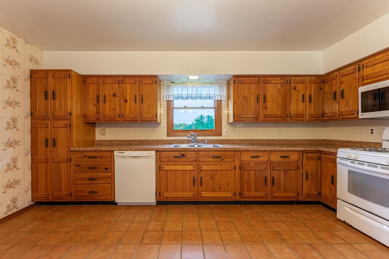 17219 Green Road Harvard, IL 60033 - Photo 13 of 44 a kitchen with stainless steel appliances granite countertop a stove a sink and a microwave