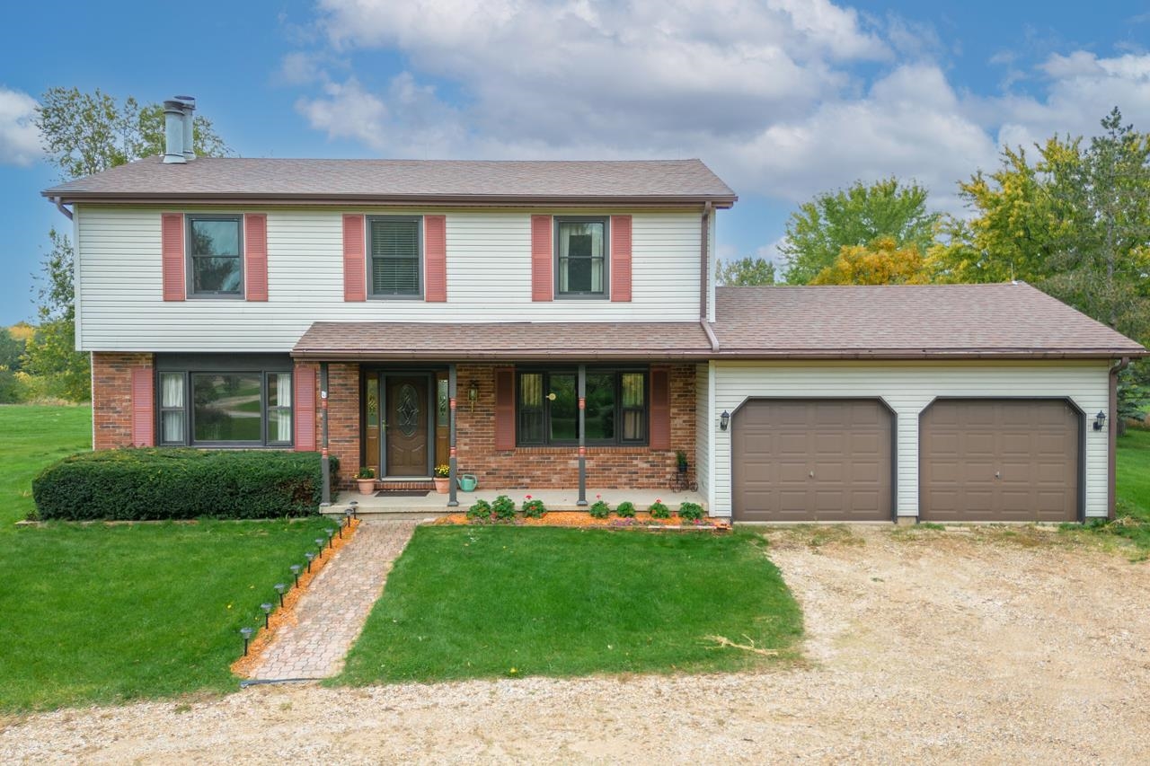 17219 Green Road Harvard, IL 60033 - Photo 3 of 44 a front view of a house with a garden and plants