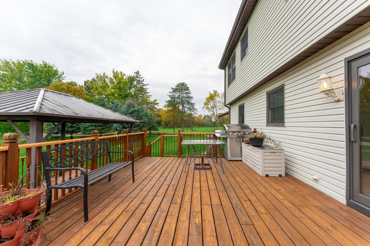 17219 Green Road Harvard, IL 60033 - Photo 37 of 44 a balcony with wooden floor table and chairs