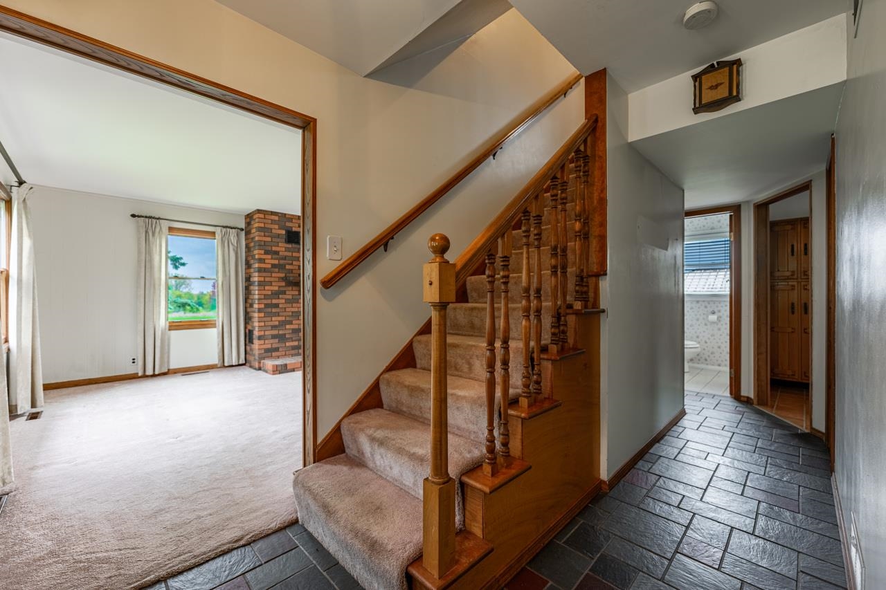 17219 Green Road Harvard, IL 60033 - Photo 7 of 44 a view of staircase with lots of frames on wall and a window
