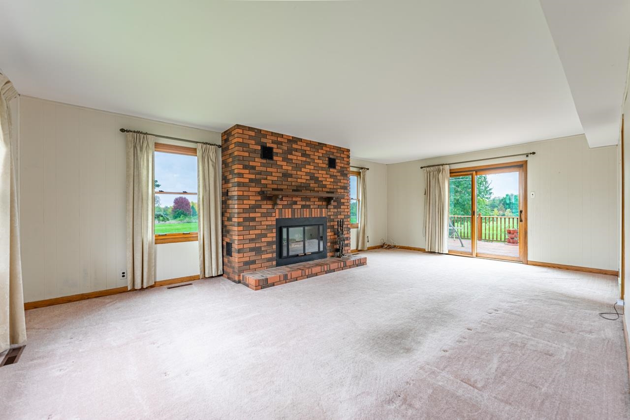 17219 Green Road Harvard, IL 60033 - Photo 8 of 44 a view of an empty room with a window and fireplace