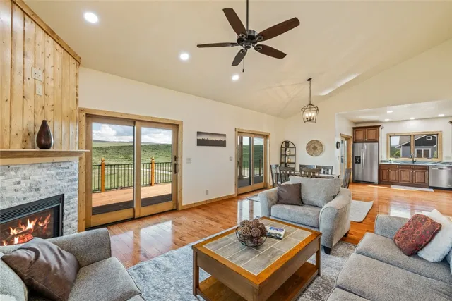 a living room with furniture a fireplace and a large window
