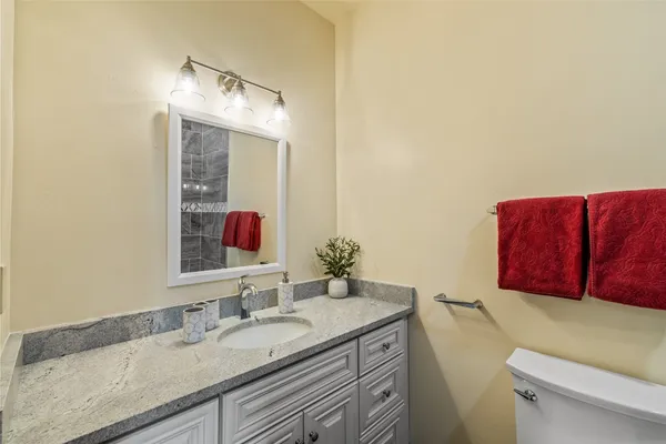 a bathroom with a granite countertop sink and a mirror