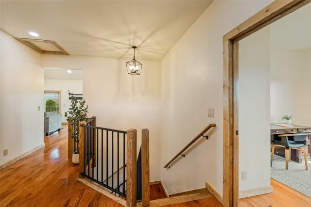 a view of a hallway with wooden floor and staircase