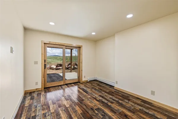 a view of empty room with wooden floor