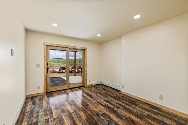a view of empty room with wooden floor