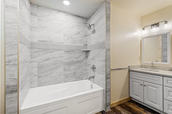 a bathroom with a granite countertop sink a toilet and bathtub