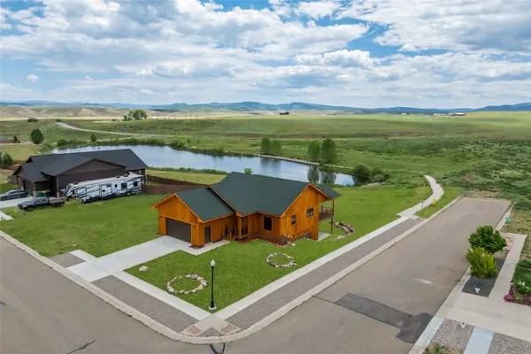 a view of a house with a big yard and a large tree