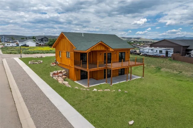a view of a house with a big yard and a large tree
