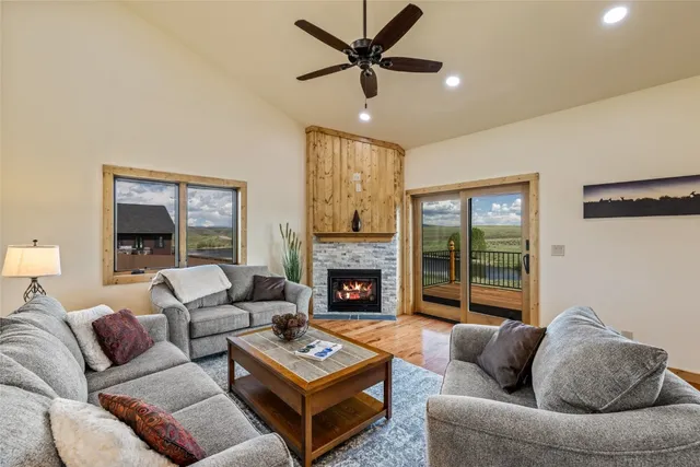a living room with furniture a fireplace and a large window
