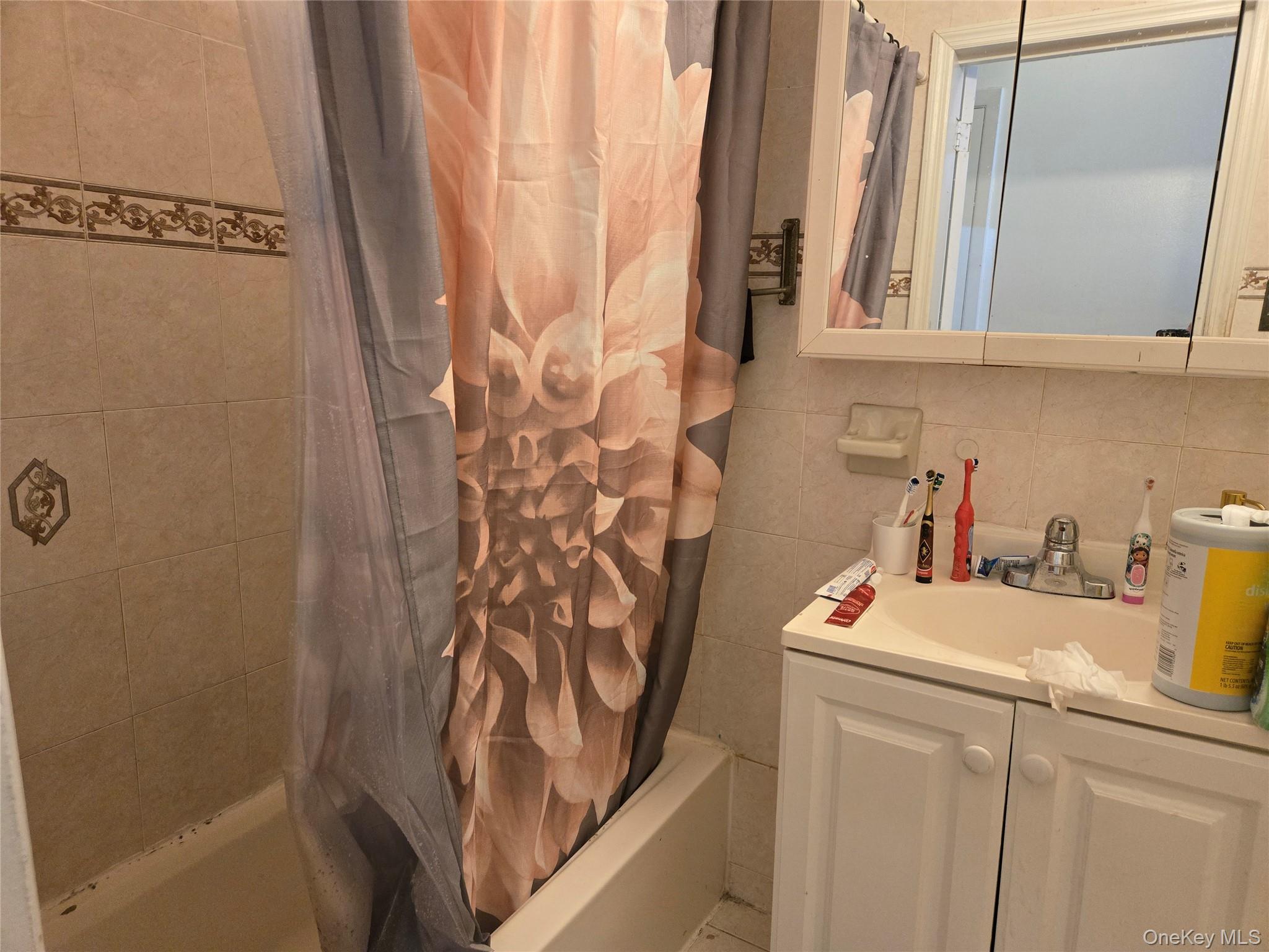 88-30 75th Street Queens, NY 11421 - Photo 19 of 23 a bathroom with a sink and a shower curtain