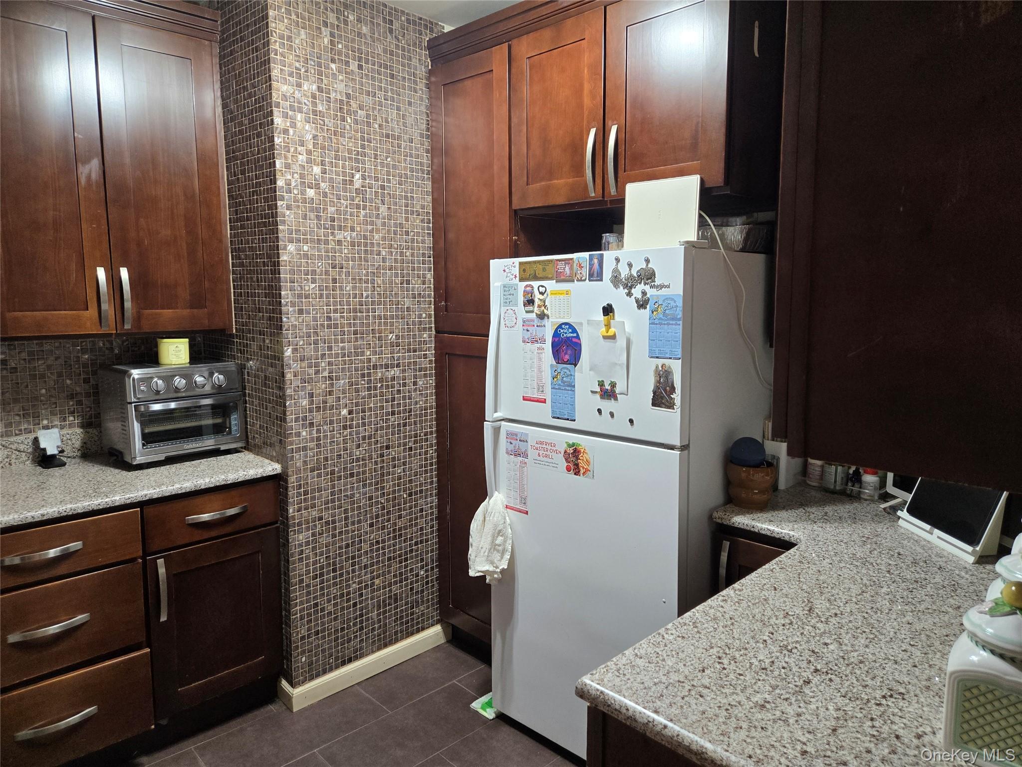 88-30 75th Street Queens, NY 11421 - Photo 9 of 23 a room with a refrigerator and a stove top oven