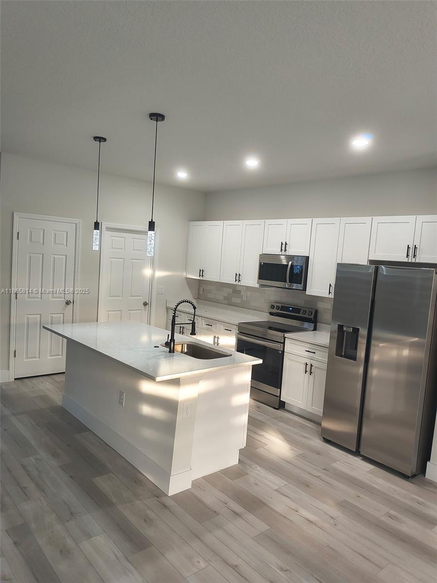 16745 Southwest 29th Terrace Ocala, FL 34473 - Photo 4 of 21 a kitchen with stainless steel appliances kitchen island granite countertop a sink a stove top oven a counter space and cabinets