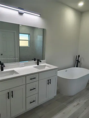 a bathroom with a double vanity sink and a mirror