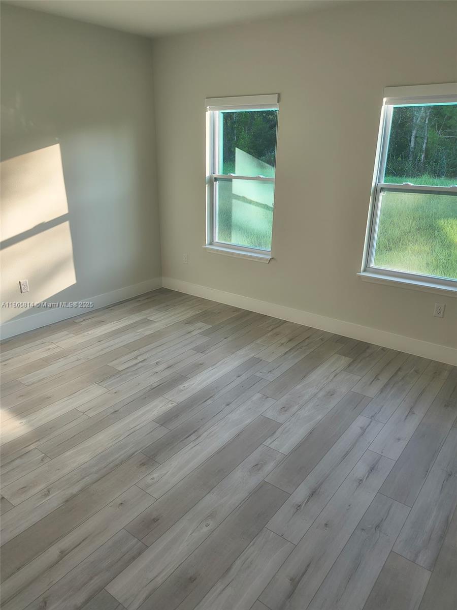 16745 Southwest 29th Terrace Ocala, FL 34473 - Photo 9 of 21 a view of an empty room with wooden floor and a window