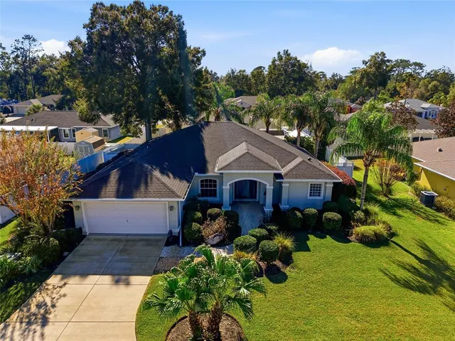 a front view of a house with a yard and mountain view in back