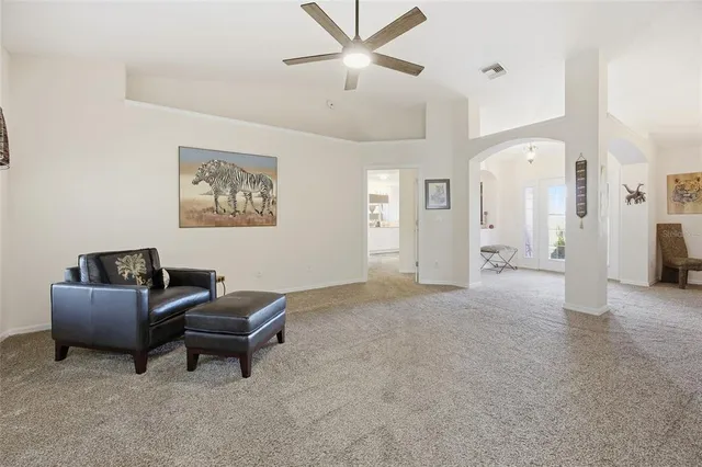 a living room with furniture and a ceiling fan