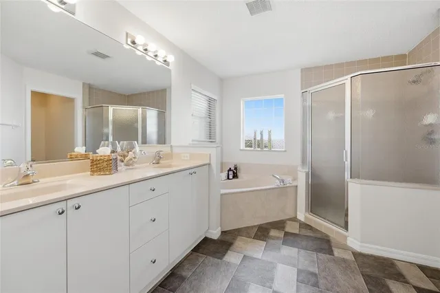 a spacious bathroom with a double vanity sink a mirror and a bathtub