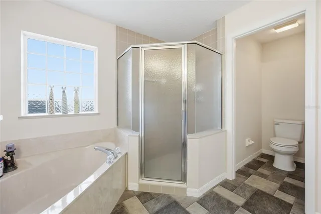 a bathroom with a tub shower and toilet