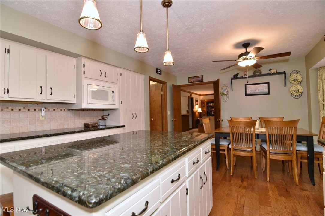 5510 Som Center Road Solon, OH 44139 - Photo 7 of 38 Kitchen with white microwave, light wood-style flooring, a ceiling fan, tasteful backsplash, and white cabinetry