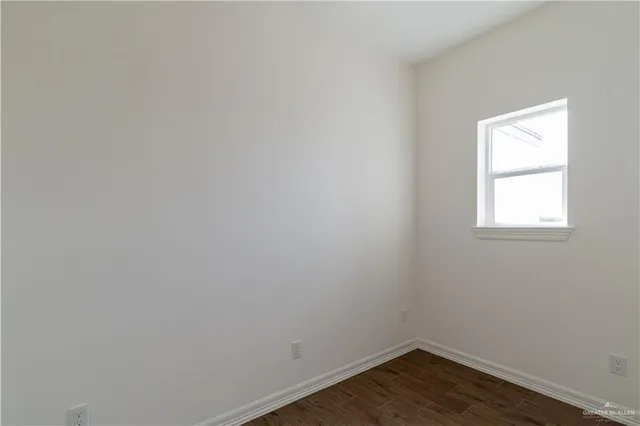 a view of a small space with wooden floor and a window