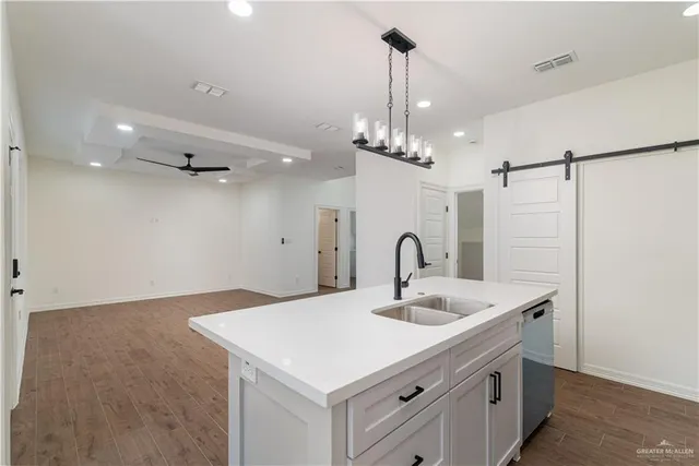 a kitchen with a sink a counter space and a refrigerator