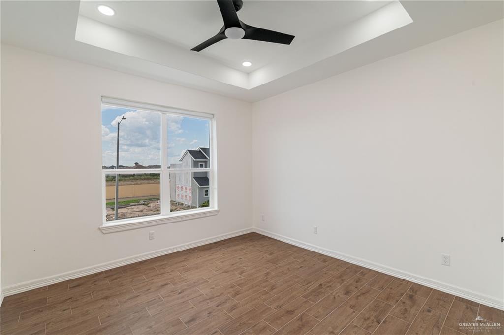 5508 North Crown Point Pharr, TX 78577 - Photo 8 of 17 an empty room with wooden floor ceiling fan and windows