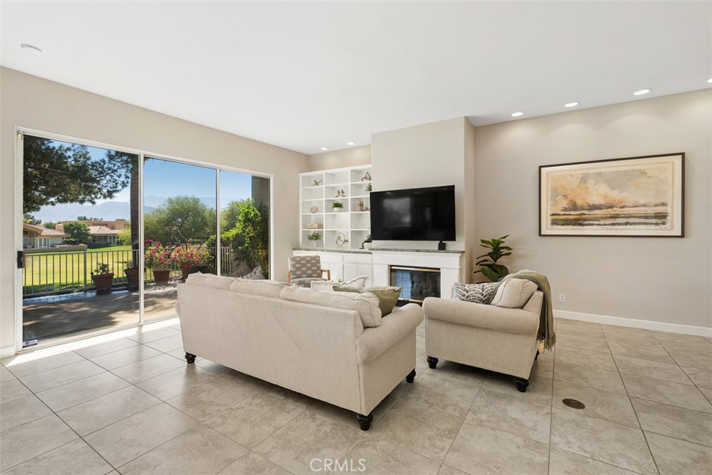 51 Pebble Beach Drive Rancho Mirage, CA 92270 - Photo 5 of 10 a living room with furniture a flat screen tv and a floor to ceiling window